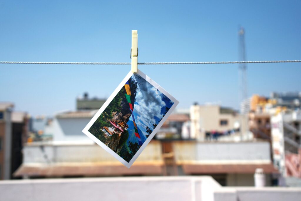 Colorful postcard hanging on a clothesline against a blurred cityscape, creating a creative urban scene.